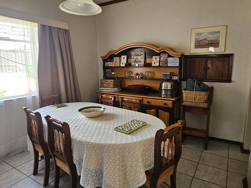A functional dining room featuring tiled flooring and a built-in wall cabinet, offering a practical space for family meals.