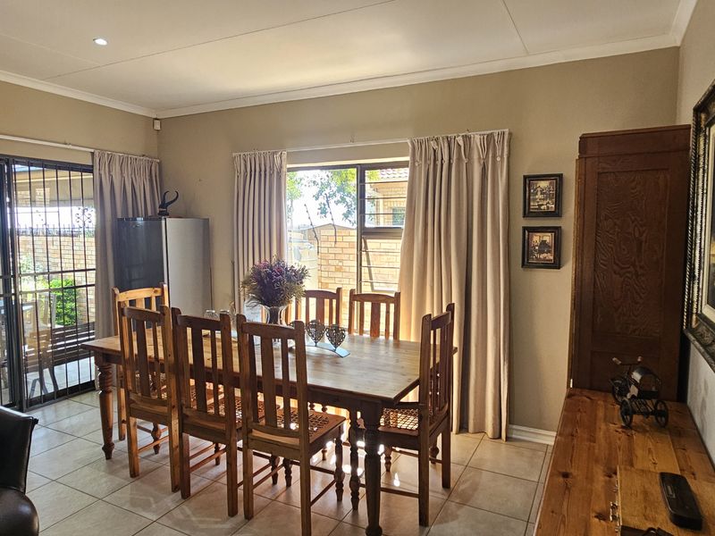 Open plan dining area featuring tiled flooring, recessed lighting, and sliding glass doors leading to an outdoor patio space.