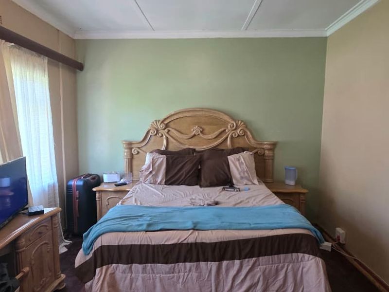 A standard bedroom featuring a built-in wardrobe and neutral wall finishes, offering a functional space ready for personal updates.