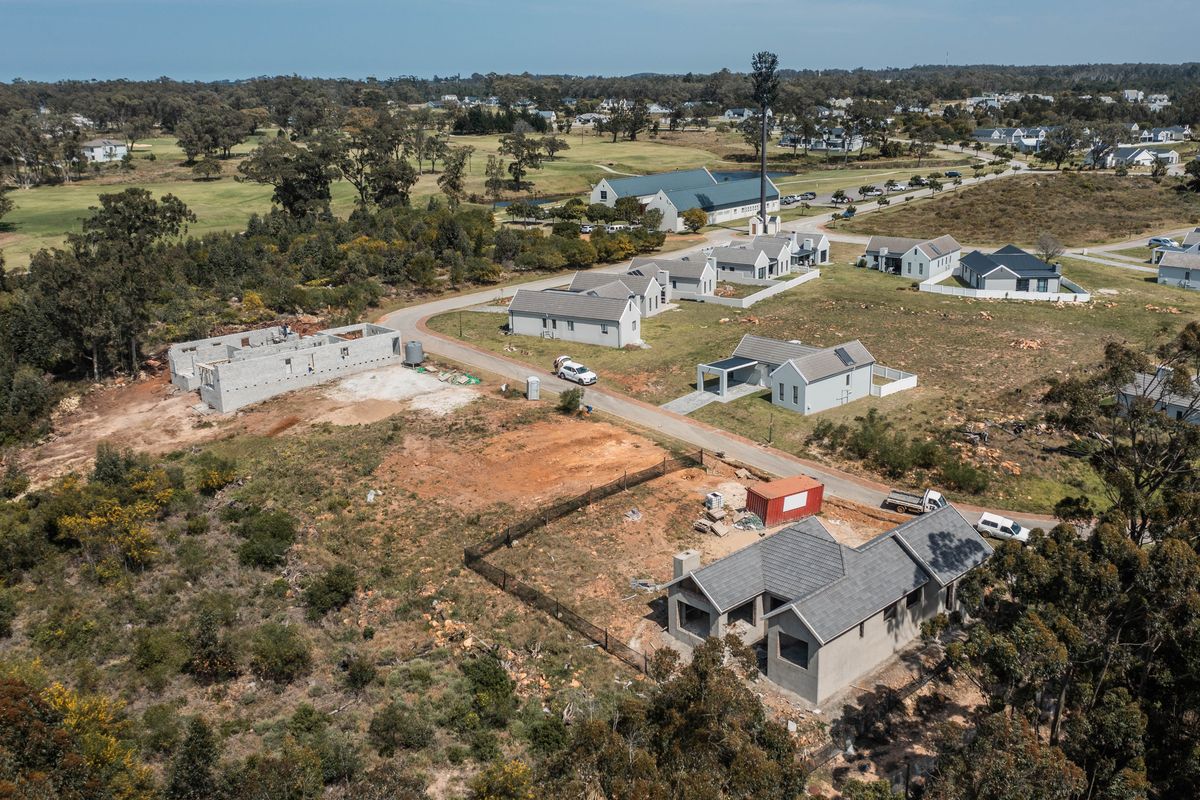 Aerial view of a residential estate development showing multiple houses in various stages of construction and surrounding landscape.