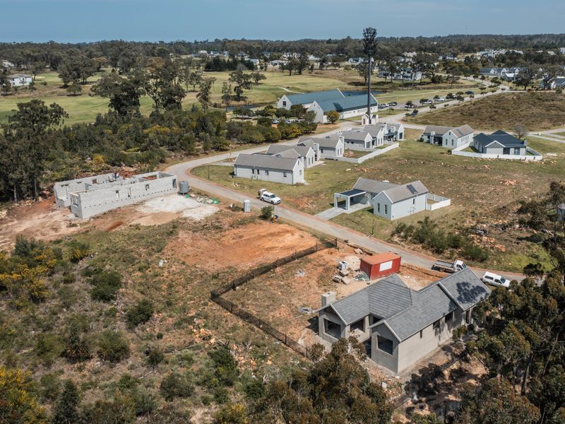 Aerial view of a residential estate development showing multiple houses in various stages of construction and surrounding landscape.