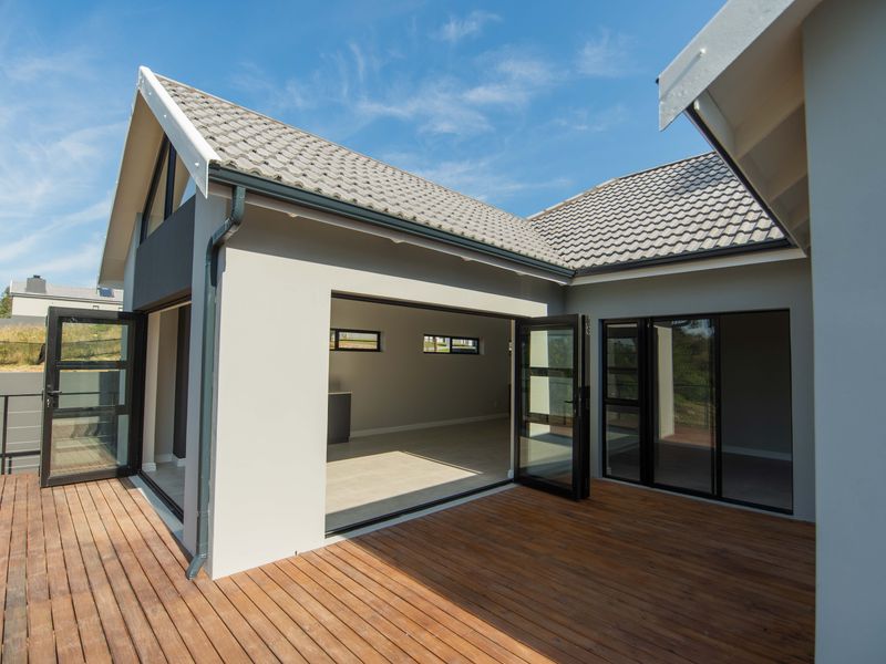 Spacious timber deck patio featuring modern aluminium stacker doors providing seamless indoor-outdoor flow to the interior living space.