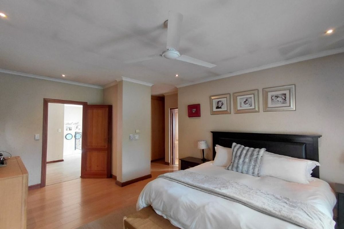 Spacious bedroom featuring laminate flooring, recessed lighting, a ceiling fan, and built-in storage, offering a comfortable and well-maintained living space.