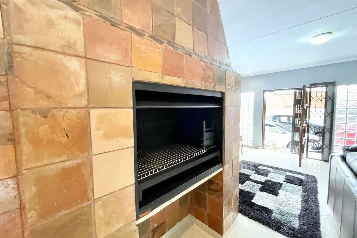 Interior living area featuring a large built-in indoor braai with terracotta tile cladding and tiled flooring.