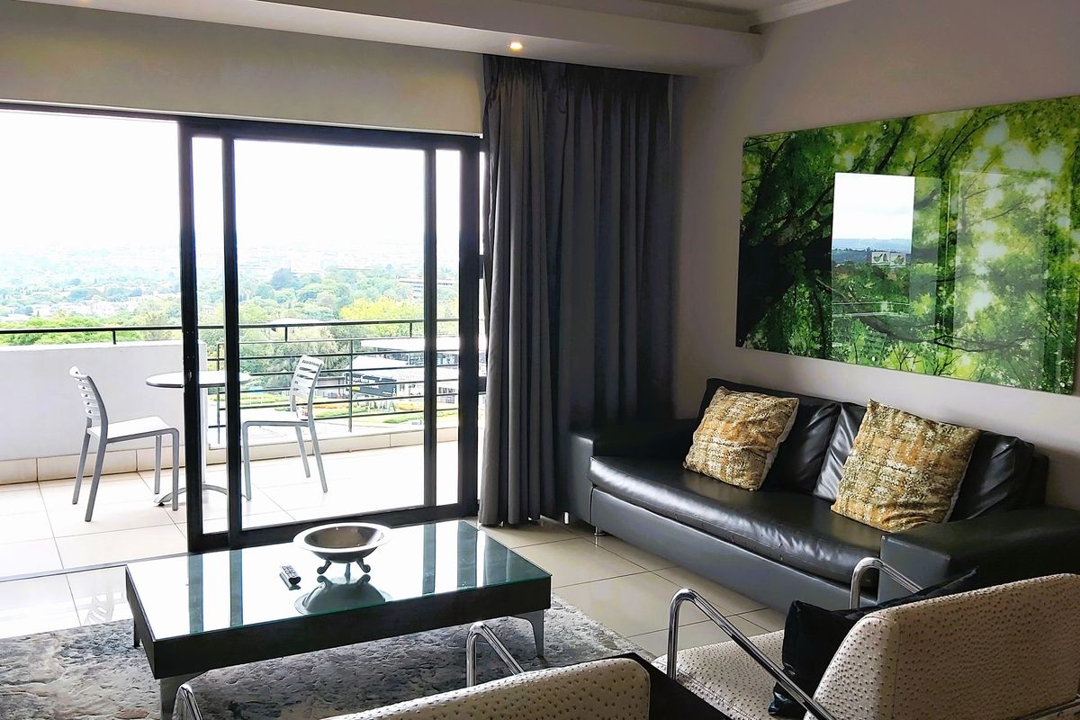 Modern living room featuring large sliding glass doors that open onto a private balcony, providing ample natural light and scenic views.