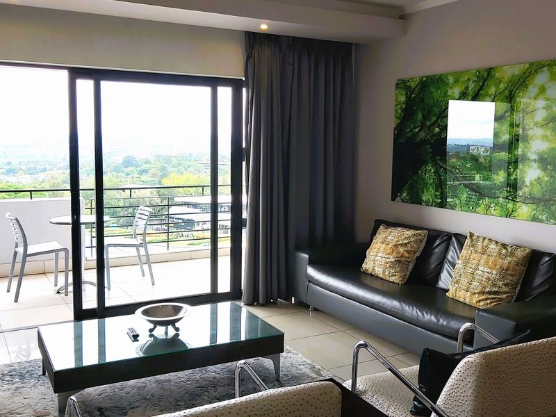 Modern living room featuring large sliding glass doors that open onto a private balcony, providing ample natural light and scenic views.