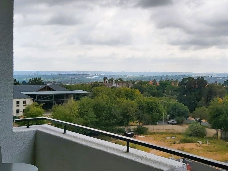 An elevated view overlooking the surrounding neighborhood and landscape from a balcony.