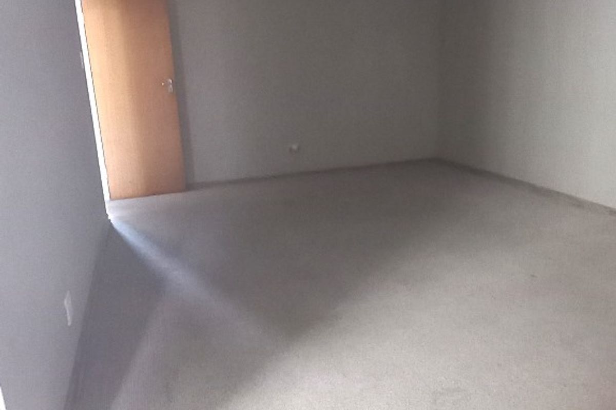 A vacant bedroom featuring neutral wall finishes and carpet flooring, providing a blank canvas for potential interior design and staging.