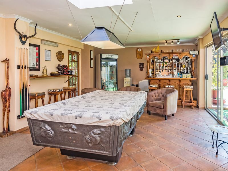 A dedicated entertainment bar area featuring a built-in bar counter, tiled flooring, and direct access to the outdoor patio through sliding glass doors.