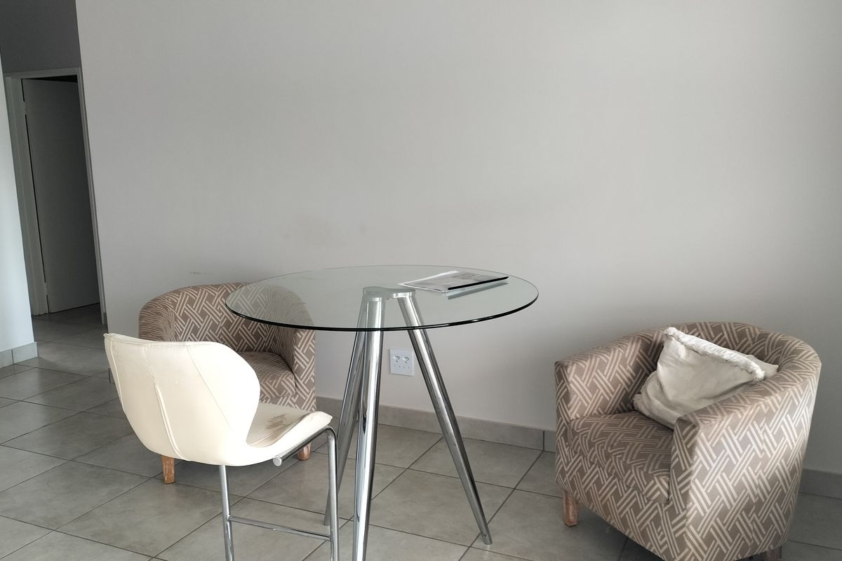 A simple living area featuring neutral tiled flooring and plain walls, providing a clean and versatile space for potential interior design updates.