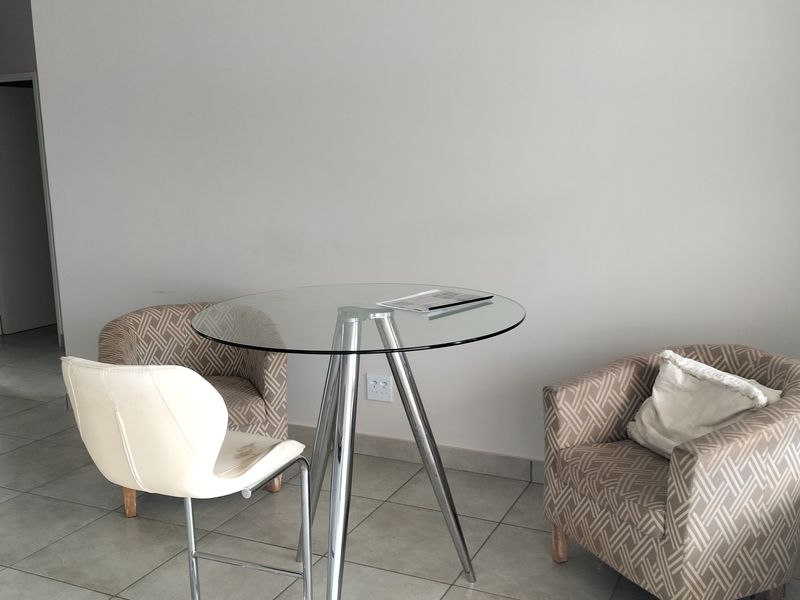 A simple living area featuring neutral tiled flooring and plain walls, providing a clean and versatile space for potential interior design updates.