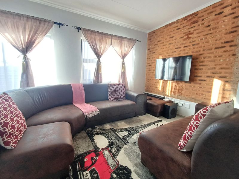 A comfortable living room featuring a distinctive exposed brick feature wall and coved ceiling details.