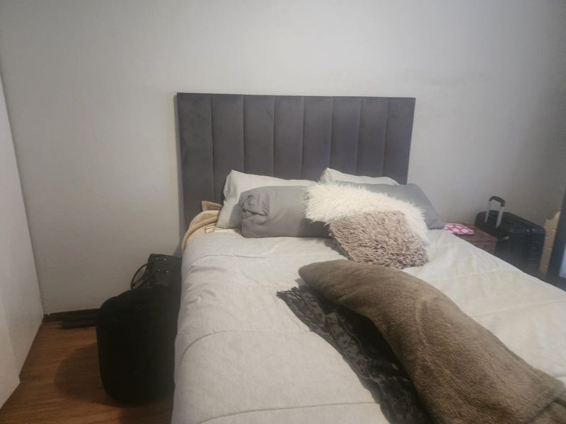 A bedroom featuring laminate flooring and a neutral wall finish, providing a simple and functional sleeping space.