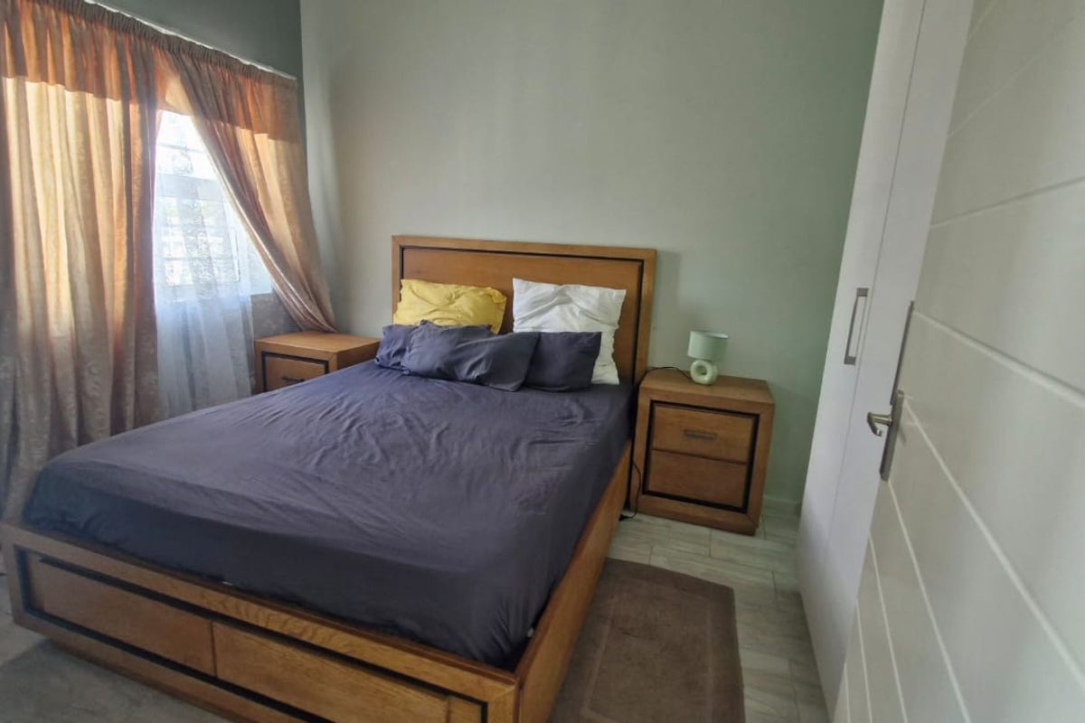 A functional bedroom featuring tiled flooring and a built-in wardrobe, offering a comfortable and practical living space.