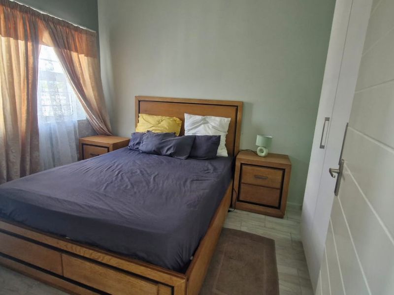 A functional bedroom featuring tiled flooring and a built-in wardrobe, offering a comfortable and practical living space.