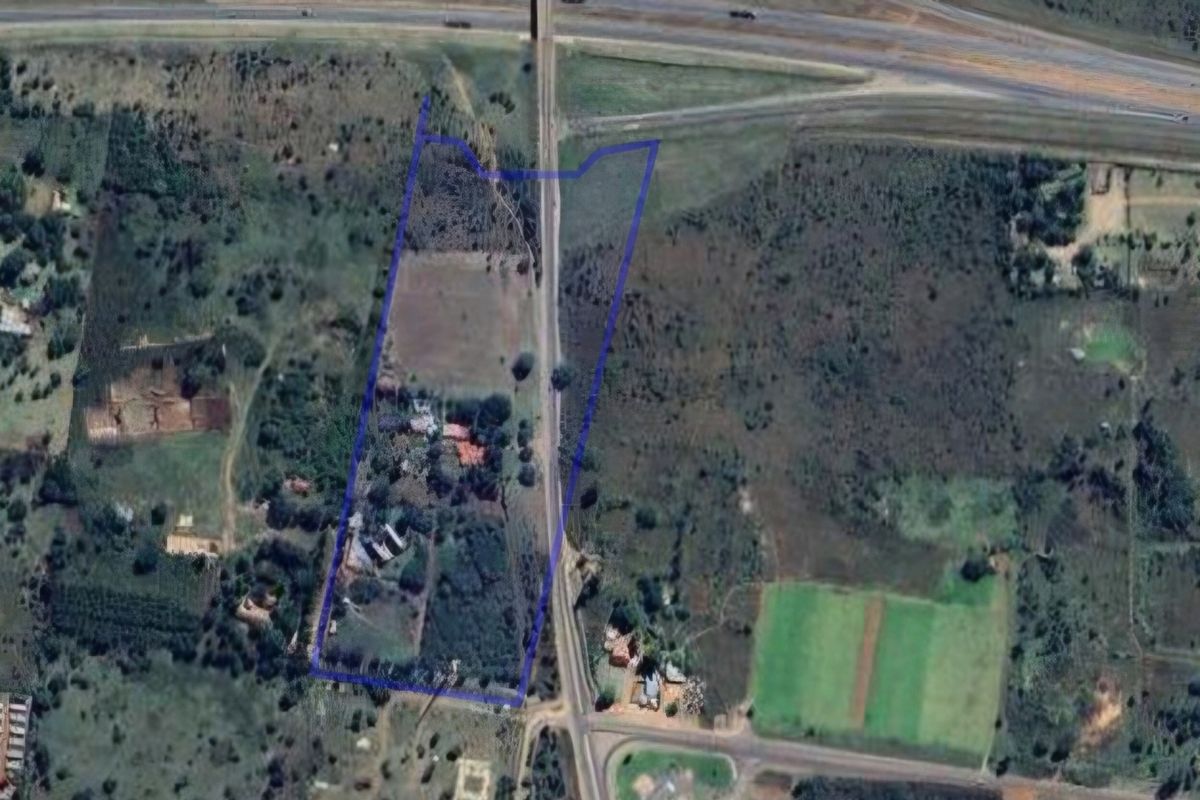 Aerial view of the farm property showing the land boundaries, surrounding vegetation, and proximity to the main road and highway infrastructure.