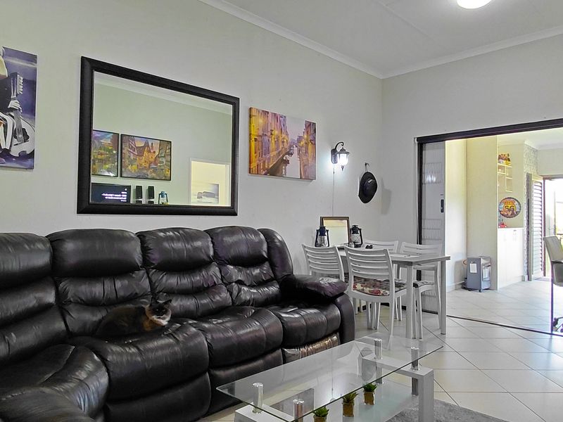Open plan living and dining area featuring tiled flooring and a sliding door leading to an adjacent space.