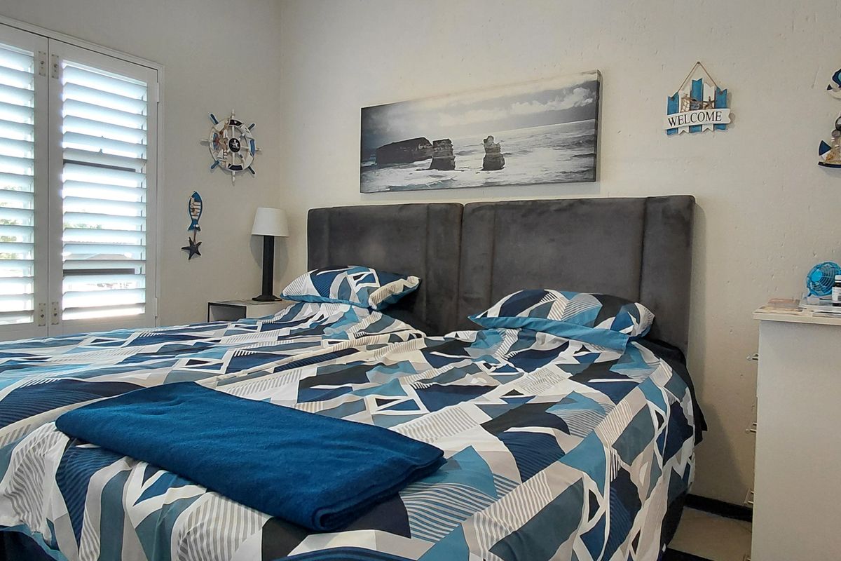 A bedroom featuring white plantation shutters, providing natural light control and a clean aesthetic.