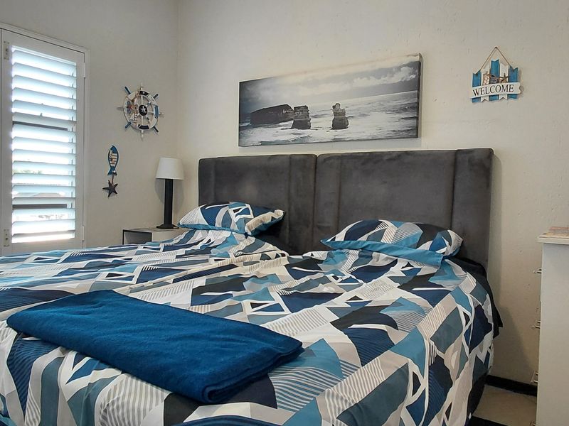 A bedroom featuring white plantation shutters, providing natural light control and a clean aesthetic.