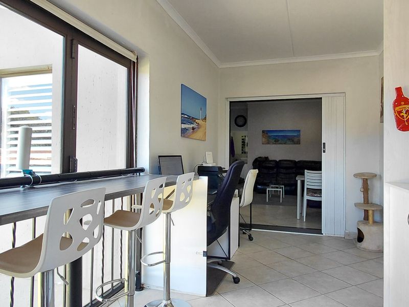 Enclosed balcony area featuring a built-in breakfast bar, tiled flooring, and direct access to the adjacent living space.