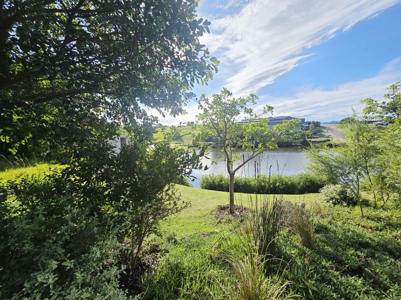 A scenic view overlooking a tranquil lake and landscaped garden area, showcasing the natural surroundings of the property.