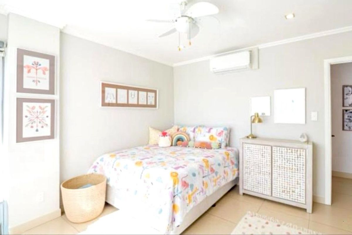 A well-maintained bedroom featuring tiled flooring, a ceiling fan, and a wall-mounted split-system air conditioner.
