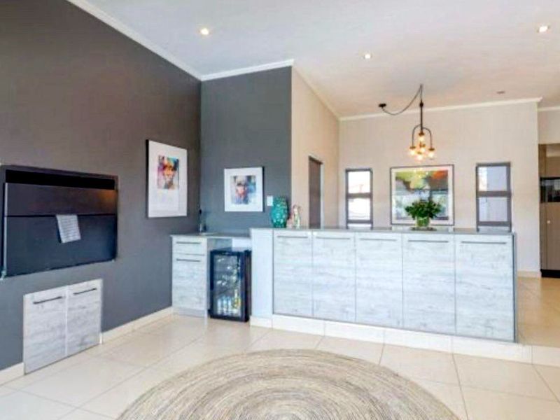 Open plan living area featuring tiled flooring, recessed downlights, and modern built-in cabinetry with an integrated fireplace.