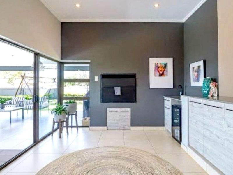 Modern living area featuring a built-in fireplace, sleek cabinetry, and large sliding glass doors that open onto a covered patio.