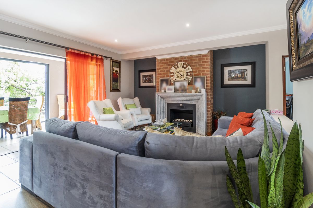 A comfortable living room featuring a prominent brick fireplace with a stone mantelpiece and large sliding glass doors providing access to the patio.