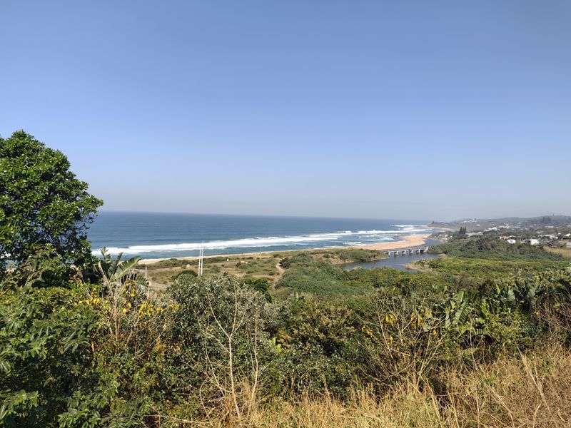 A scenic elevated view overlooking the coastline, beach, and natural estuary landscape.