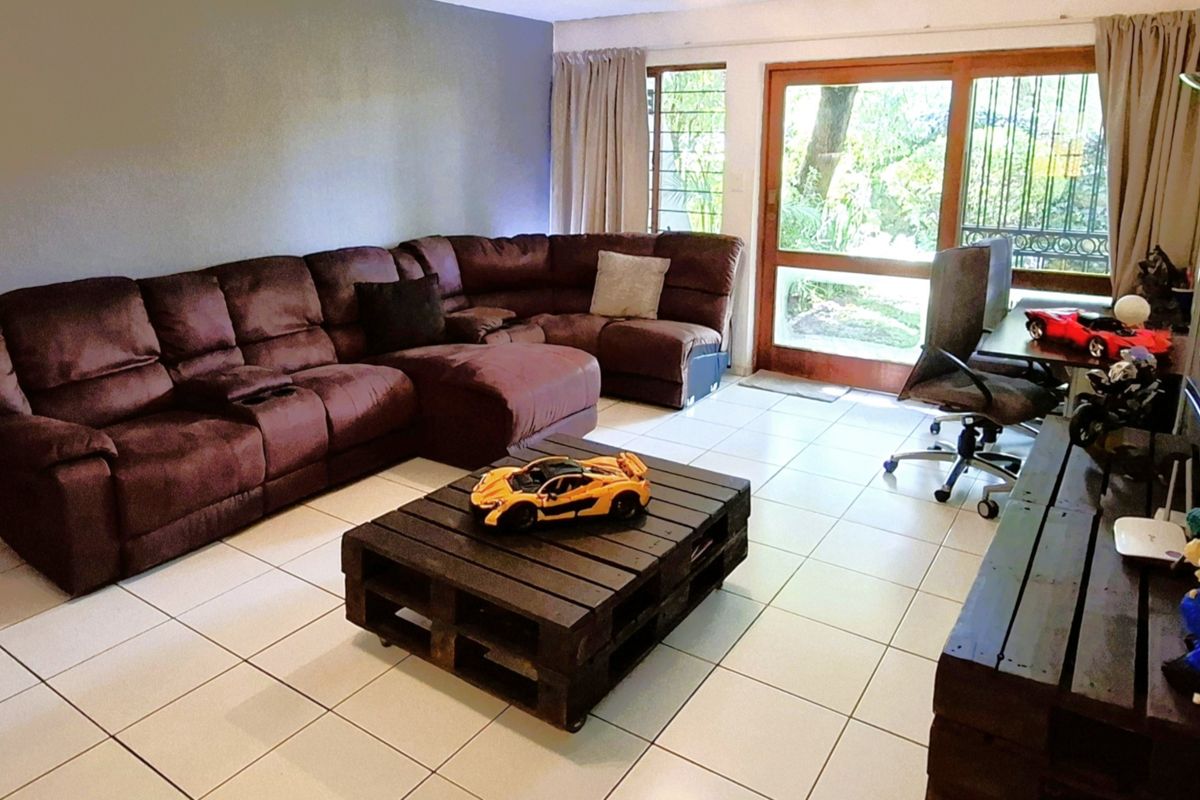 Spacious living room featuring light-colored floor tiles and a large sliding glass door providing direct access to the outdoor area.