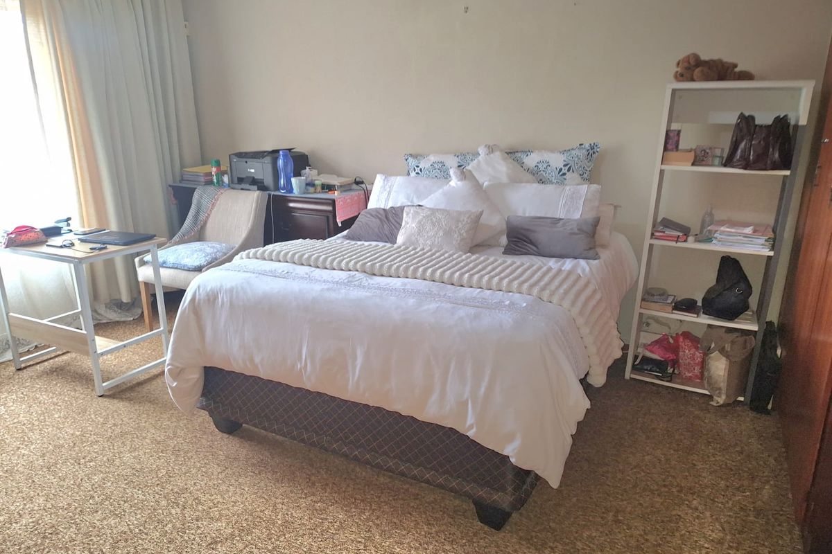 A bedroom featuring carpeted flooring and a built-in cupboard, offering a functional space that could benefit from modern updates.