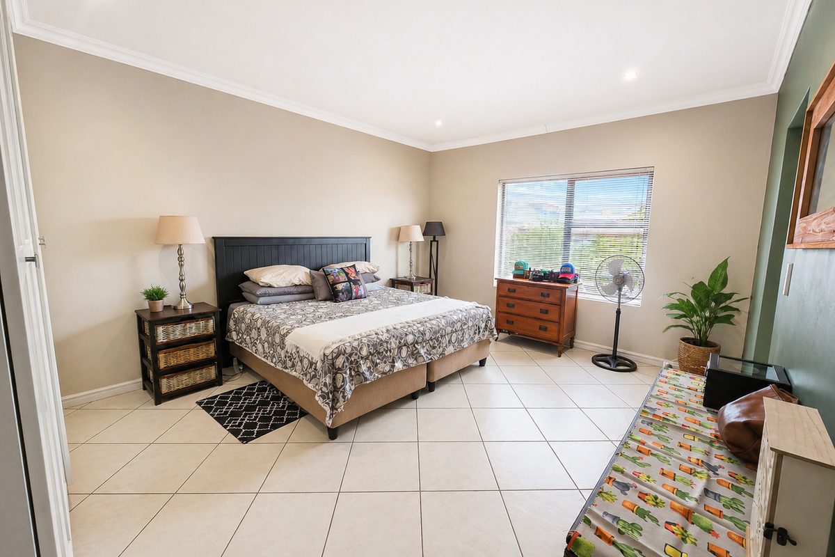 Spacious bedroom featuring neutral wall tones, tiled flooring, recessed downlighting, and large windows allowing for ample natural light.
