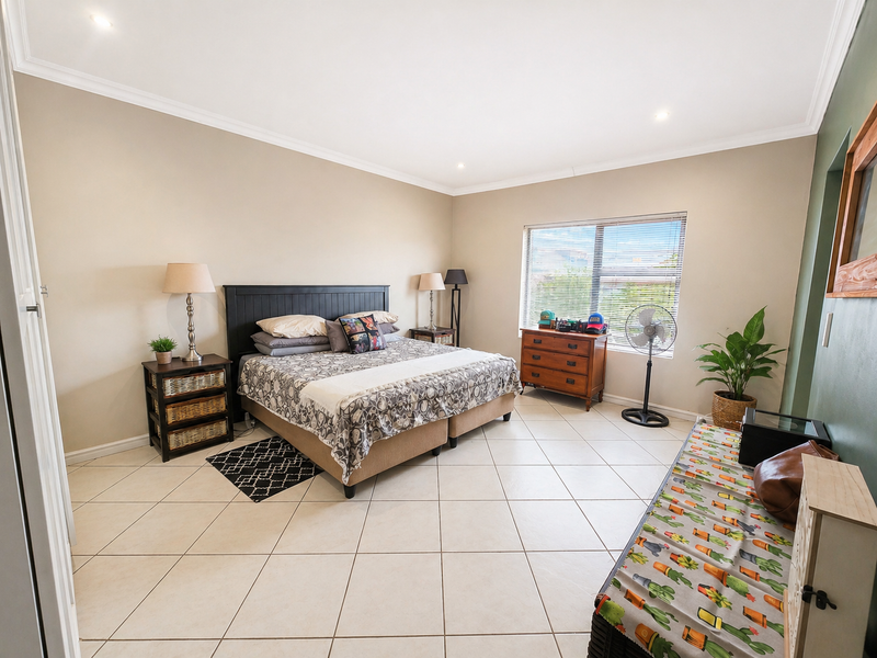 Spacious bedroom featuring neutral wall tones, tiled flooring, recessed downlighting, and large windows allowing for ample natural light.