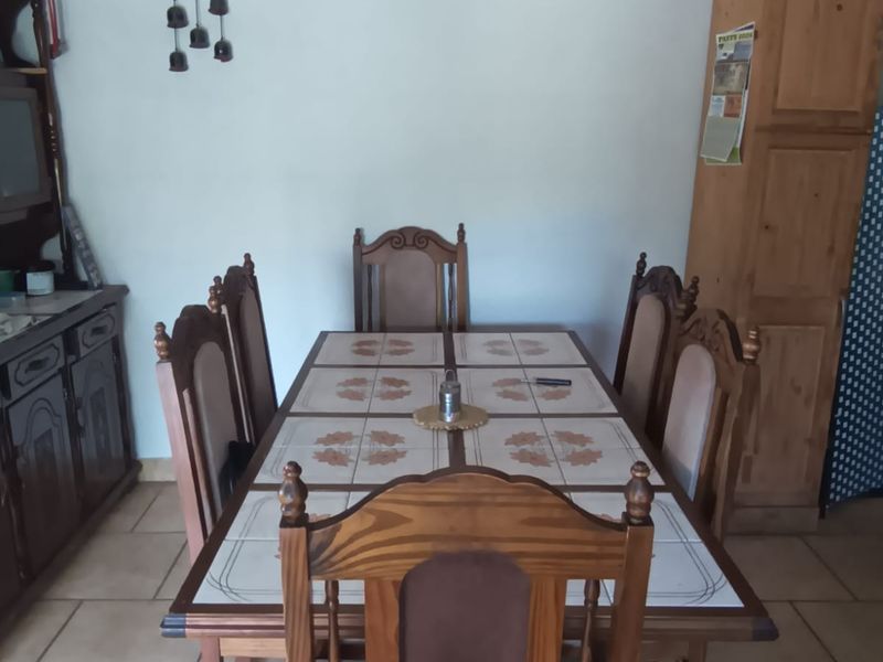 A dining room featuring tiled flooring and a ceiling fan, providing a functional space for family meals.