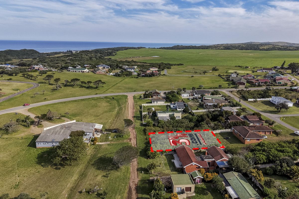 Aerial view of a vacant residential land plot situated in a coastal neighborhood, highlighting the property boundaries and surrounding landscape.