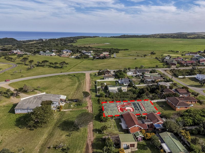 Aerial view of a vacant residential land plot situated in a coastal neighborhood, highlighting the property boundaries and surrounding landscape.