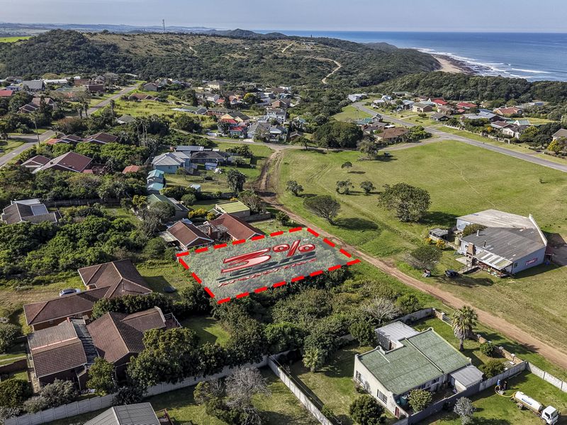Aerial view of a vacant residential land plot situated in a coastal neighborhood, highlighting the property boundaries and surrounding landscape.