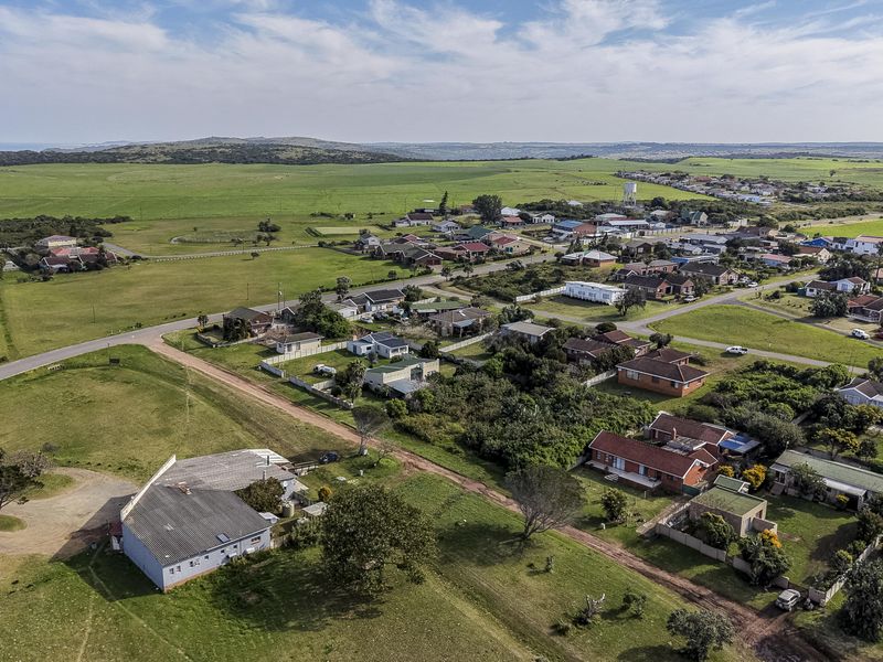 An aerial view of the residential area and surrounding landscape, showcasing the property's location within the neighborhood and proximity to the coast.