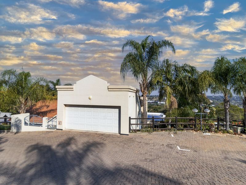 Front exterior view of the townhouse featuring a single garage, paved driveway, and landscaped surroundings.