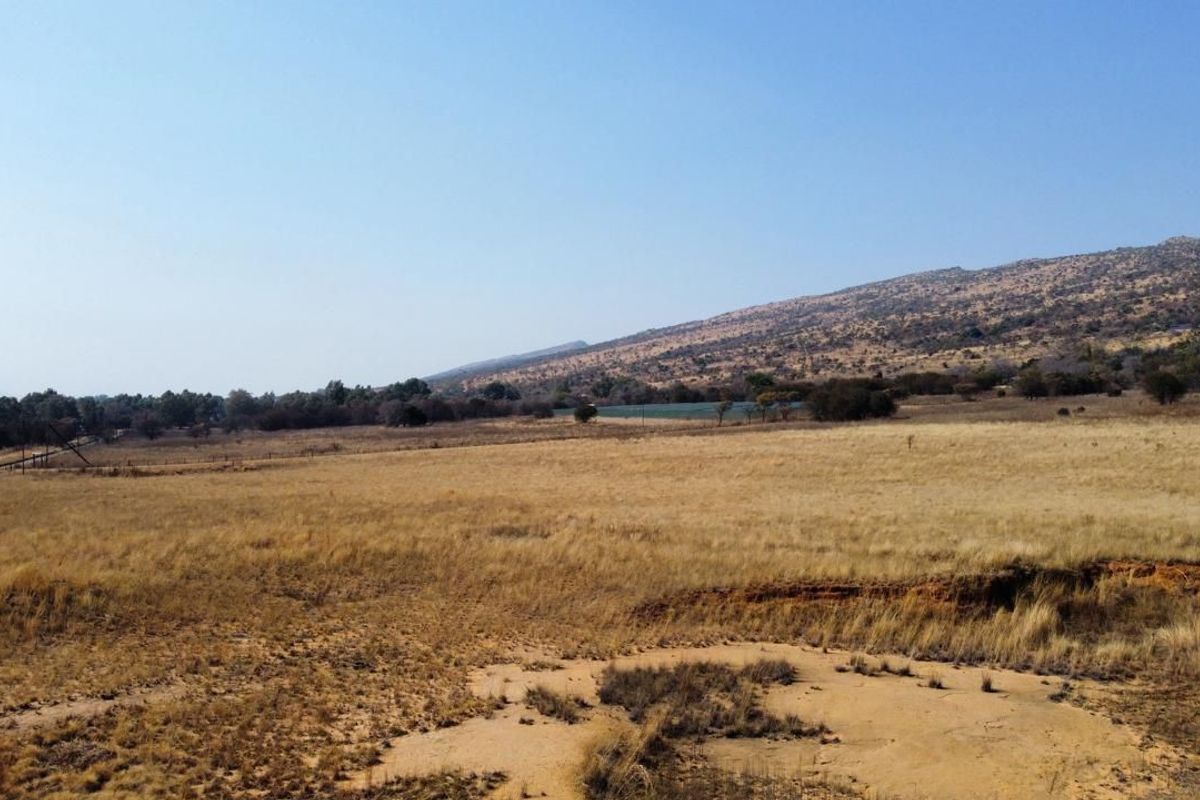 Expansive view of the farm property featuring open grassland and a scenic mountain backdrop.
