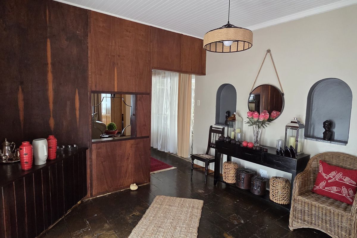 A living area featuring dark stone flooring, built-in wooden cabinetry, and decorative arched wall niches, creating a warm and traditional atmosphere.