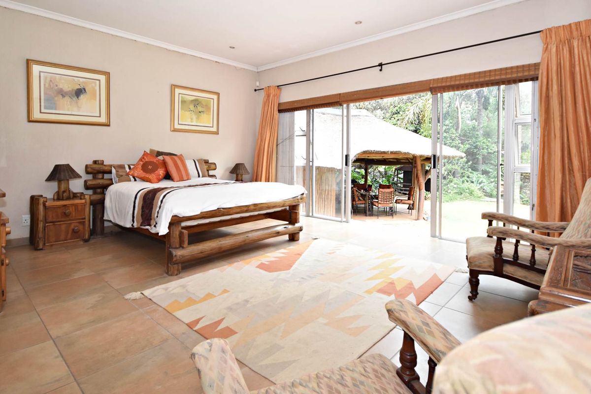Spacious bedroom featuring tiled flooring and large sliding glass doors that provide direct access to an outdoor patio area.