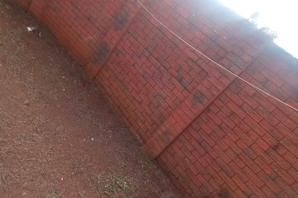 A private rear outdoor area featuring a high brick boundary wall and an installed washing line, currently requiring landscaping and maintenance.