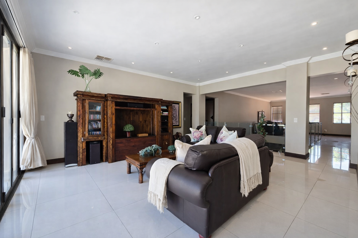 Spacious living area featuring large format porcelain floor tiles, recessed downlighting, and sliding glass doors leading to the exterior.