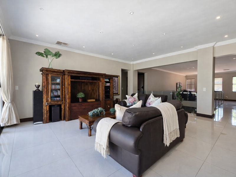 Spacious living area featuring large format porcelain floor tiles, recessed downlighting, and sliding glass doors leading to the exterior.
