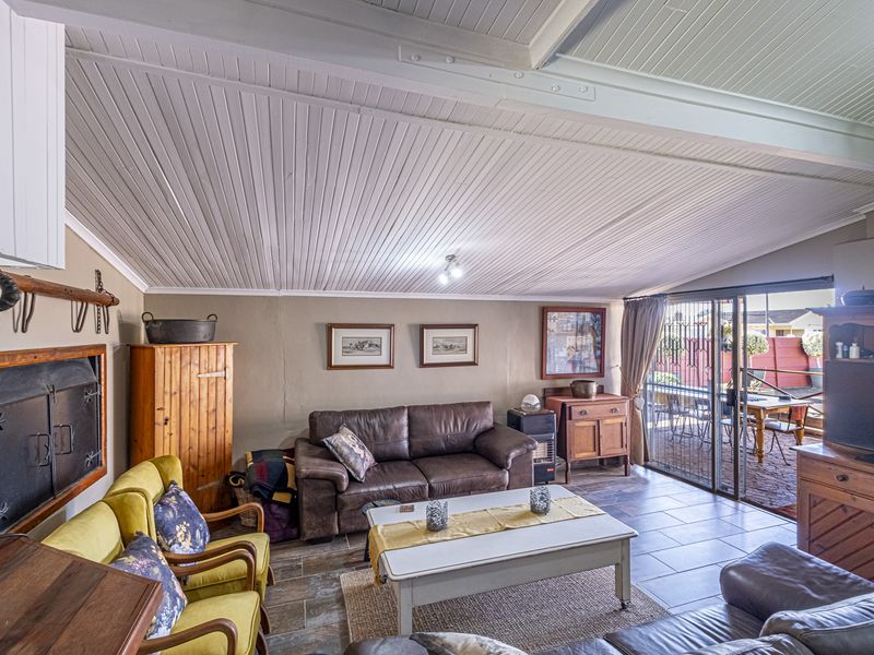 Spacious living room featuring a built-in fireplace, tiled flooring, and sliding glass doors that open to an outdoor patio area.