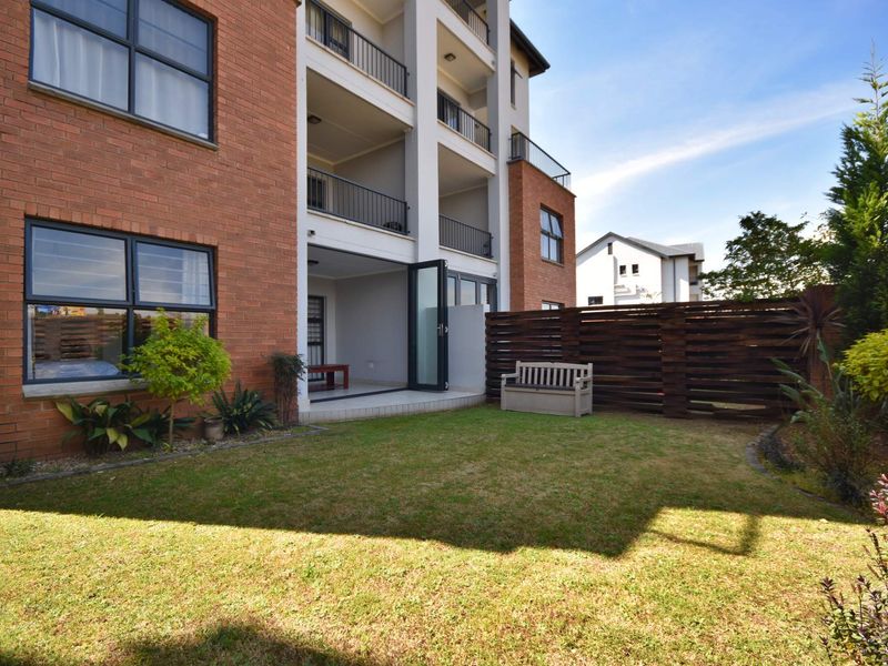 Ground floor apartment featuring a private garden, tiled patio area, and direct access through sliding glass doors to the main living space.