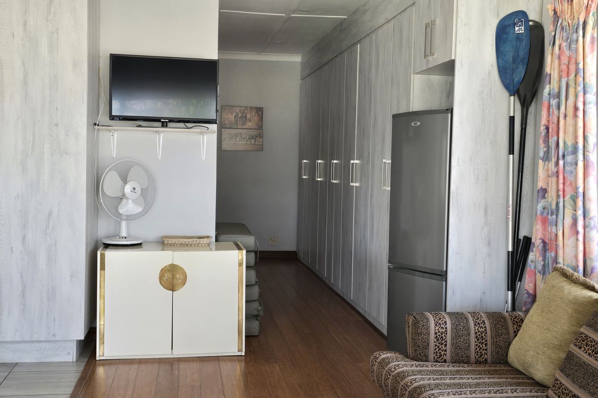 A functional living space featuring extensive built-in cabinetry, wood-look flooring, and a neutral interior finish.