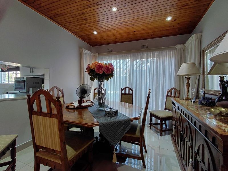 Dining room featuring a warm timber tongue and groove ceiling, tiled flooring, and a sliding glass door providing access to the exterior.